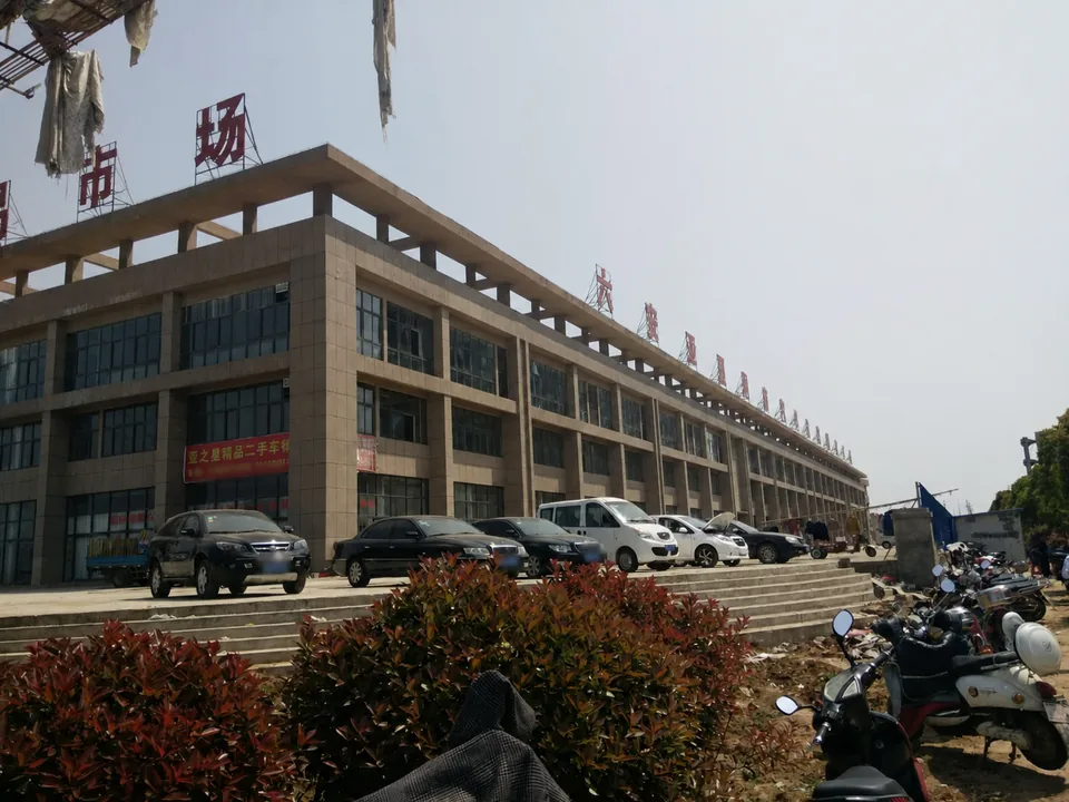 六安汽车文化财富广场沿街商铺、车辆与园区往来场景实景